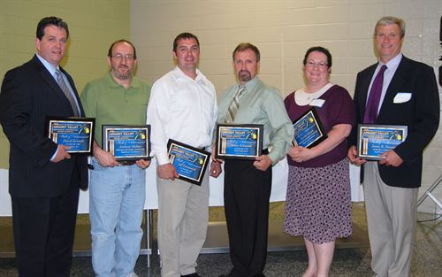 Hall of Achievement winners pose in a group with their plaques